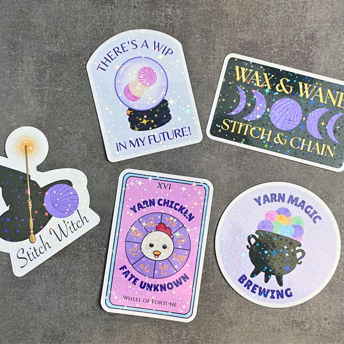 Set of colorful stickers with yarn-themed designs on a gray surface