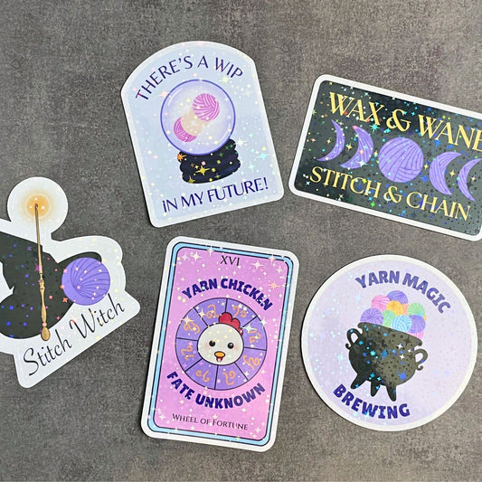 Set of colorful stickers with yarn-themed designs on a gray surface